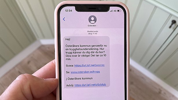 En mobiltelefon visar sms med länk till trygghetsmätningen
