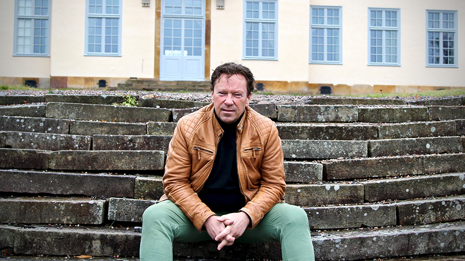 Roger Persson i skinnjacka sitter på en stentrappa.