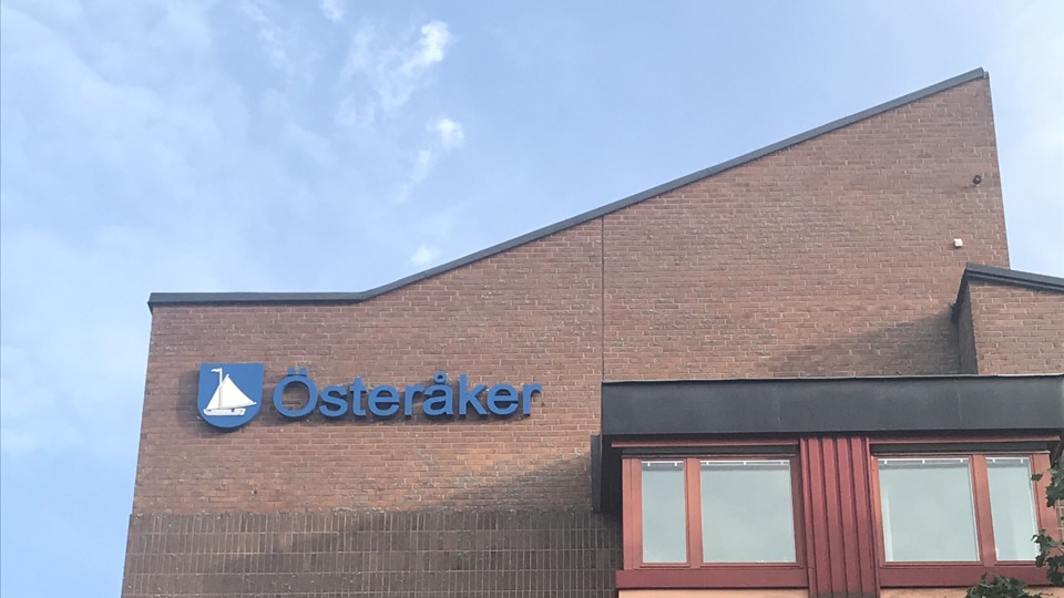 Del av kommunhuset Alceahusets tegelfasad med Österåkers kommuns logotyp på fasaden.