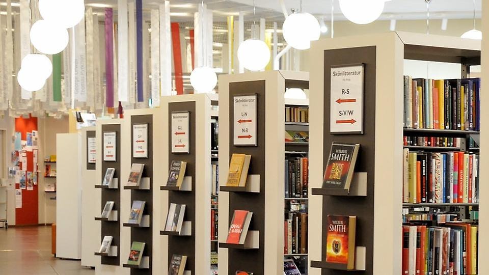 Bokhyllor på Österåkers bibliotek syns snett från sidan