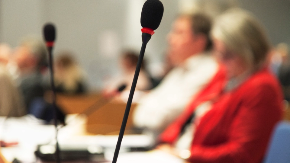 En grupp människor som sitter vid ett bord med mikrofoner.