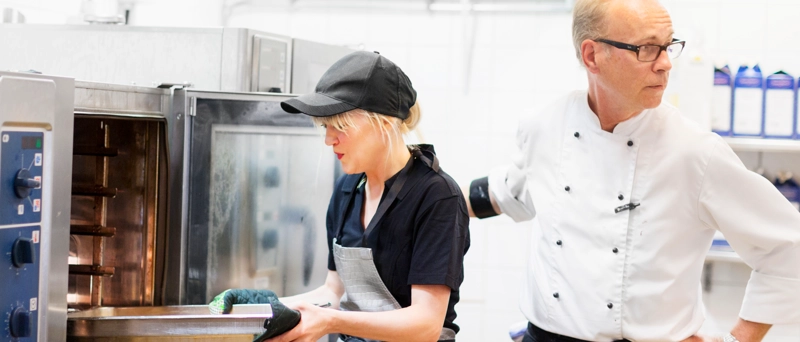 En man och en kvinna arbetar i ett kök.