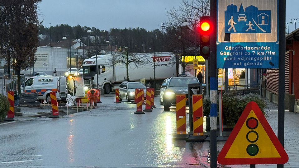 Stationsvägen en regnig morgon med skyltar för vägarbete och trafiksignaler.