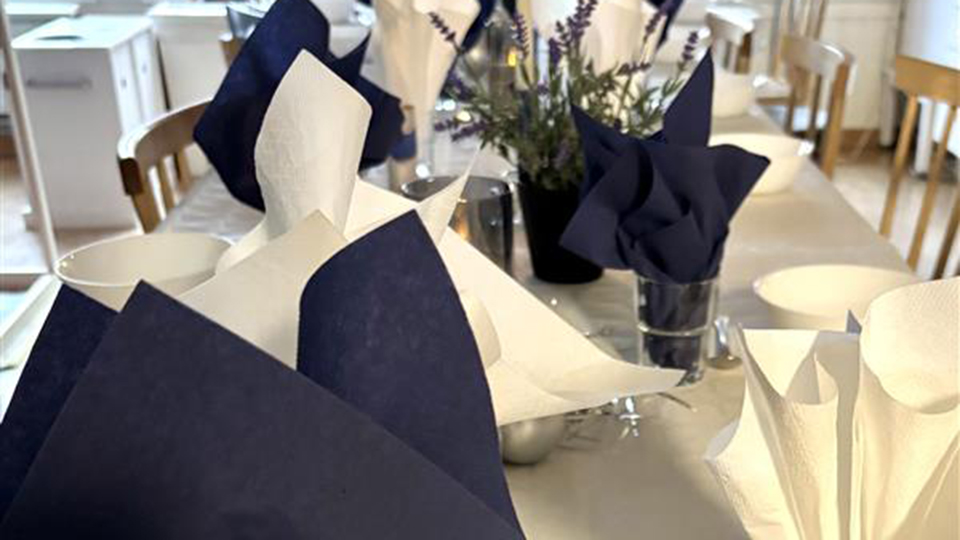 Katettu pöytä Suomen lippuineen ja posliinein