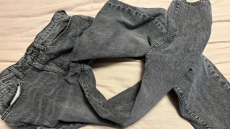 Ett par slitna och urtvättade jeans ligger ihopskrynklade.