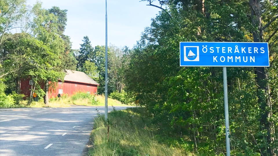 En blå gatuskylt som sitter vid sidan av en väg.