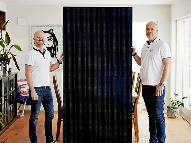 Porträtt på Robert och Andreas som håller i en solcell från varsin sida.
