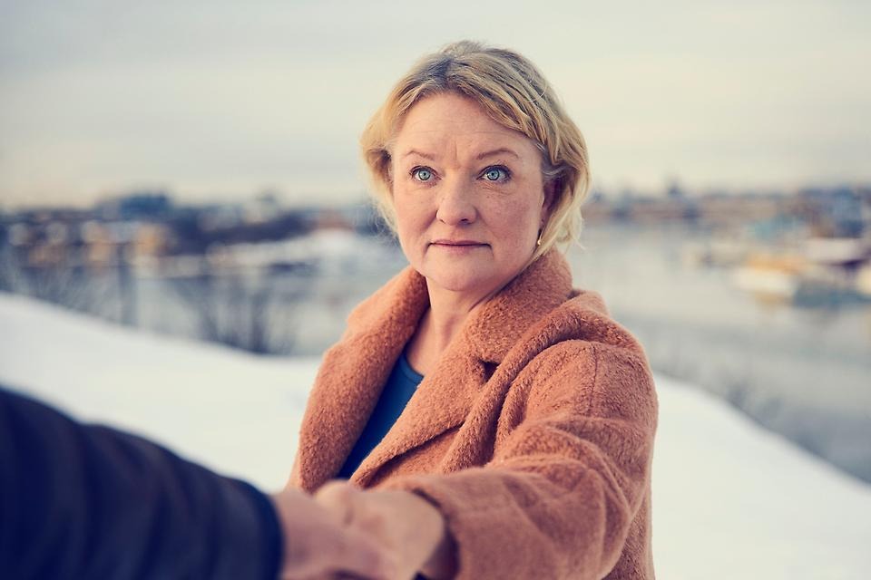 Porträttbild av en ljushårig kvinna i vinterlandskap