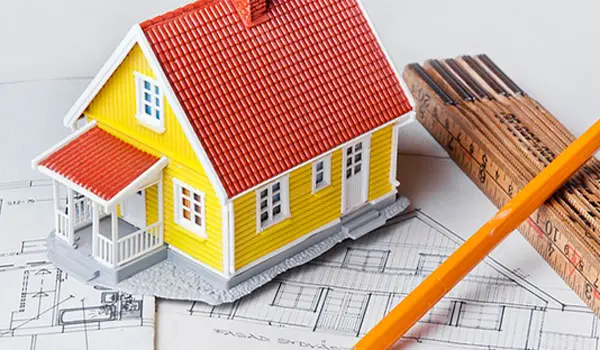 Litet gult hus i forma av en modell som står på ritningar