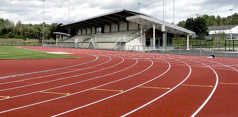 löparbanor på en friidrottsarena. En läktare syns i bakgrunden