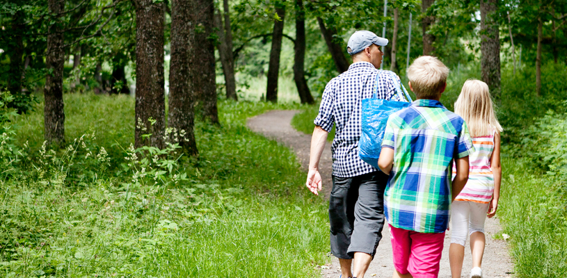 familj ute och går på led i skogen