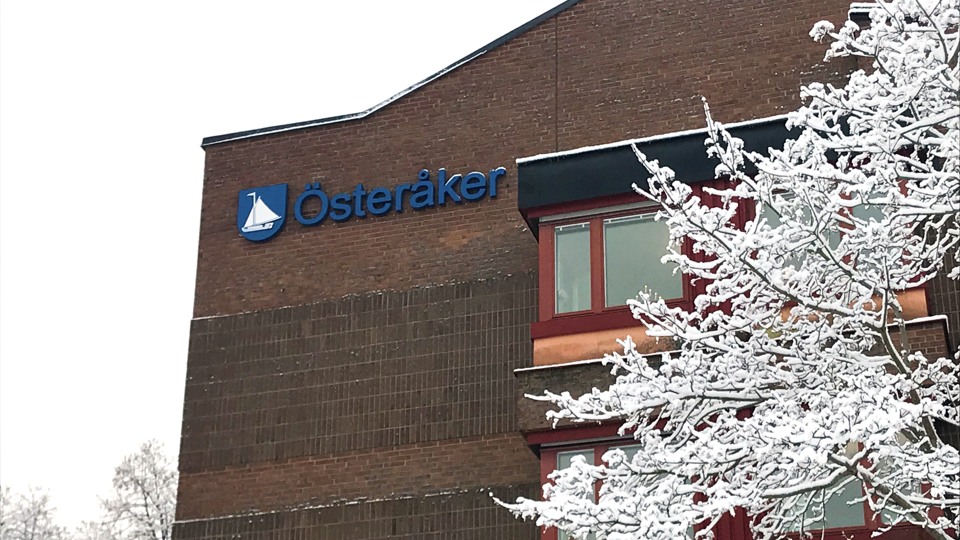 Bilden visar kommunhuset Alcea en vinterdag. På den bruna tegelfasaden sitter Österåkers kommuns logga.