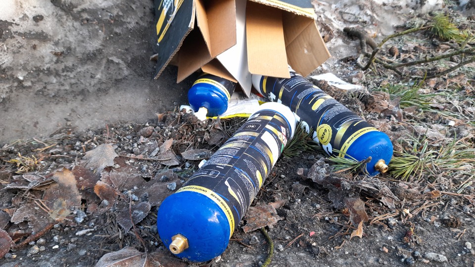 Bilden visar flera gräddsifoner som ligger på marken.
