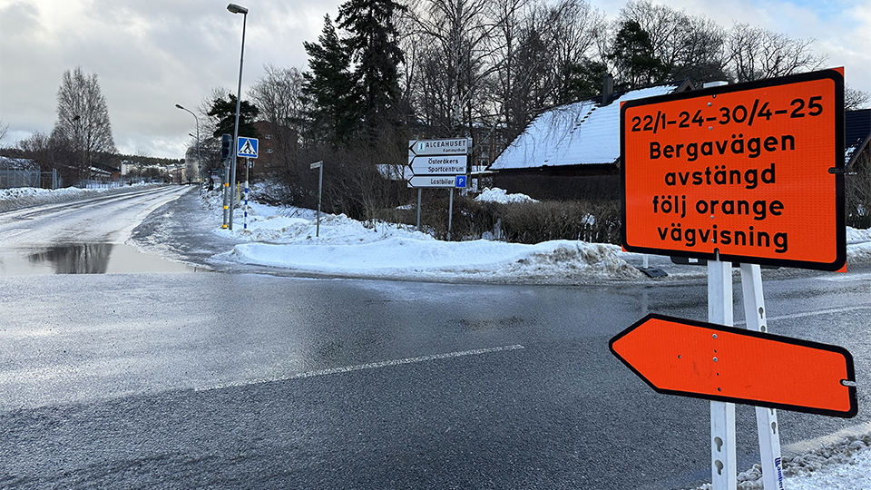 En starkt orange skylt med texten 22/1-24-30/4-25 Bergavägen avstängd följ orange vägvisning.