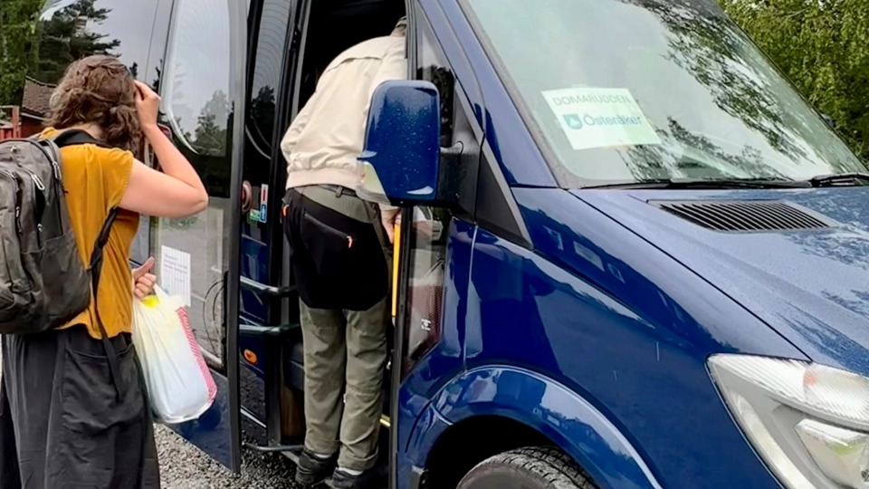 Äldre person går på en mindre buss.