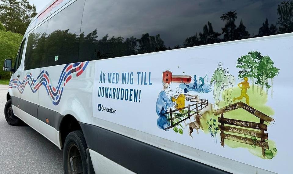 Vit buss med en skylt där det står "Åk med mig till Domarudden"