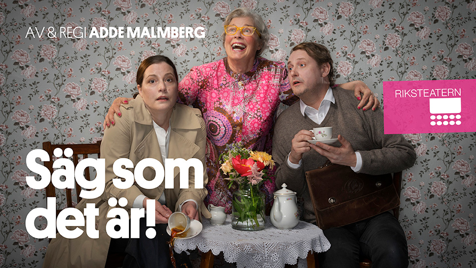 En kvinna och en man i yngre medelålder sitter vid ett prydligt kaffebord. Bakom dem står en mycket äldre dam med armarna om deras axlar och ett stort leende.