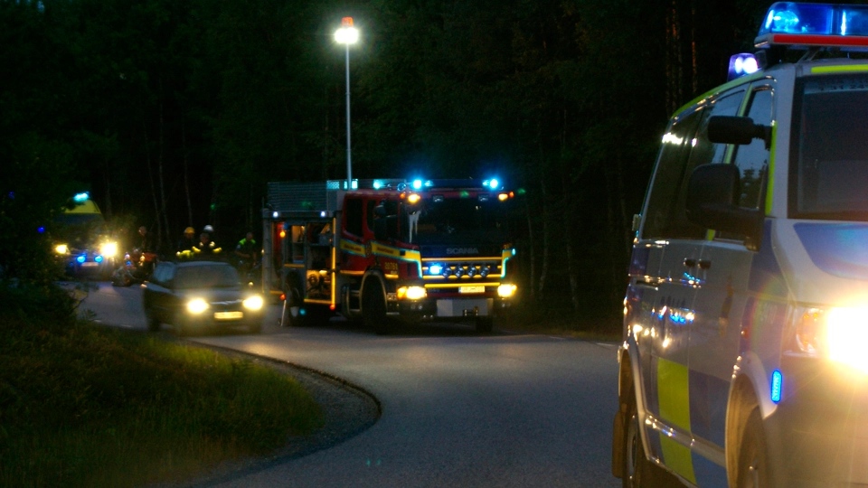 En brandbil och polisbil med blåljus på i mörker