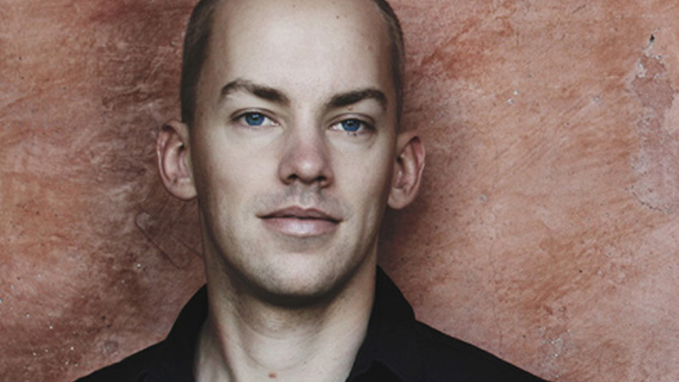 En man med snaggat hår och ganska stora öron ser in i kameran.