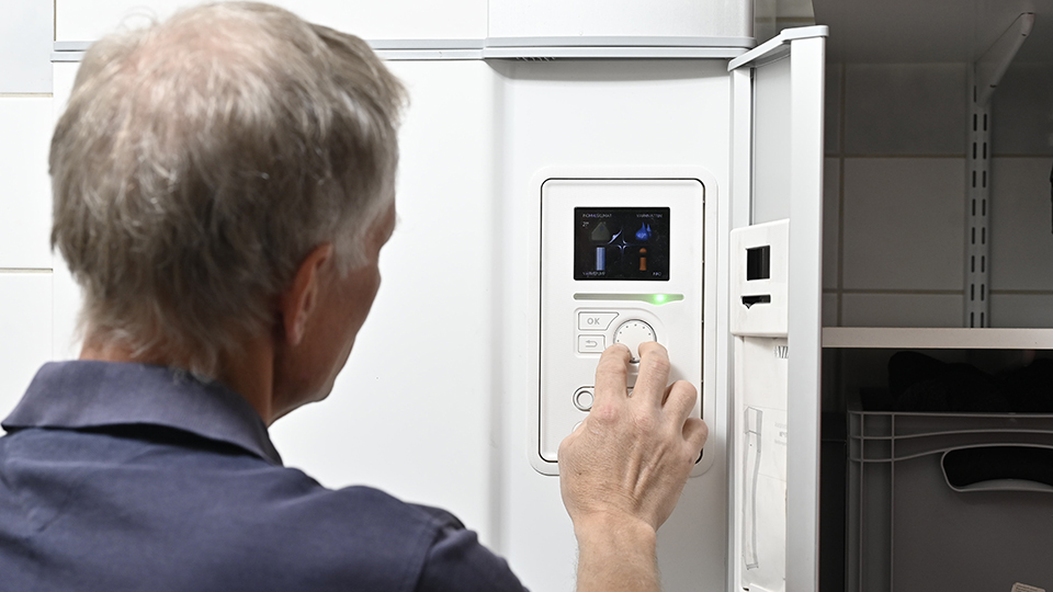 Person trycker på en skärm på en värmepump