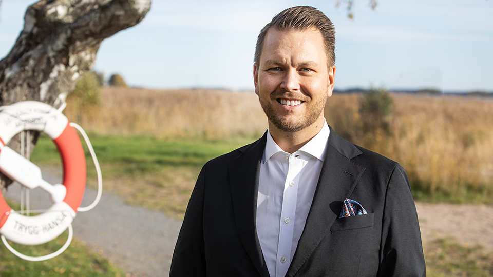 Richard Orgård står leende i skärgårdsmiljö.