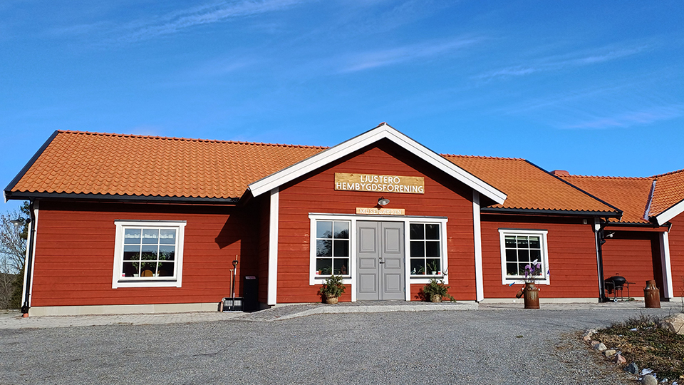 Museigården - ett rött trähus med vita knutar och med rullstolsramp till entrén.