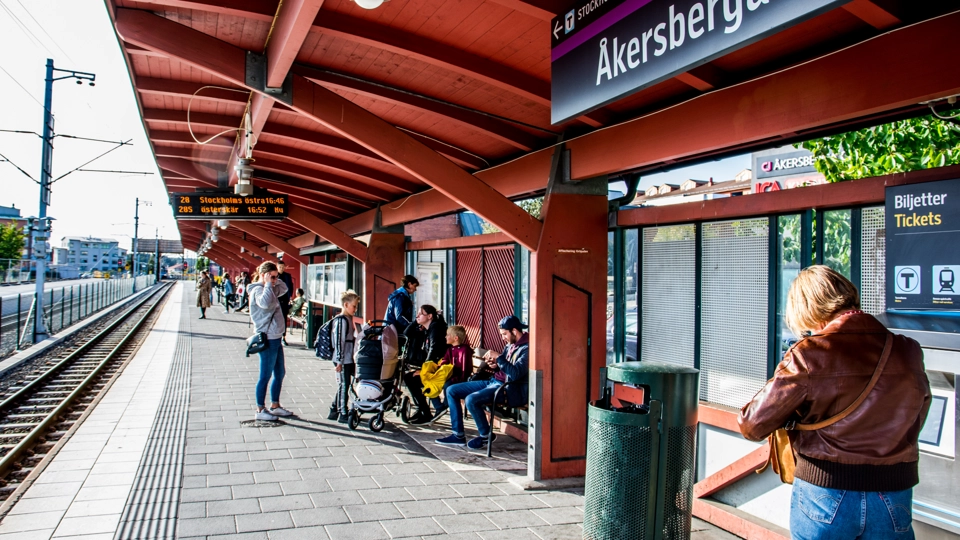Perrongen till Åkersberga station. I bakgrunden syns en grupp ungdomar som pratar med varandra.
