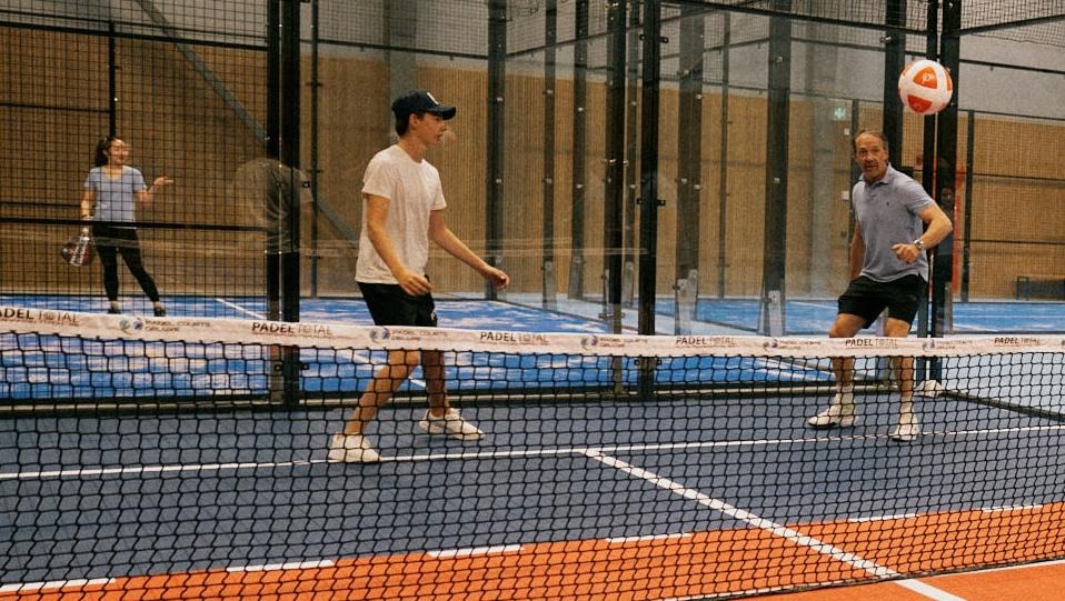 Ungdomar i träningshall som spelar bollsport.