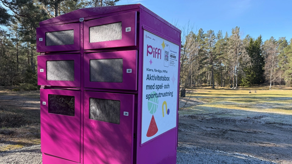 En lila låda som står på en grusplan. Lådan är full av aktivitetsutrustning.