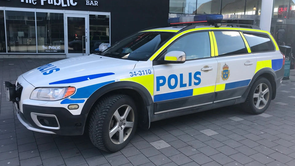 En polisbil parkerad framför en byggnad.