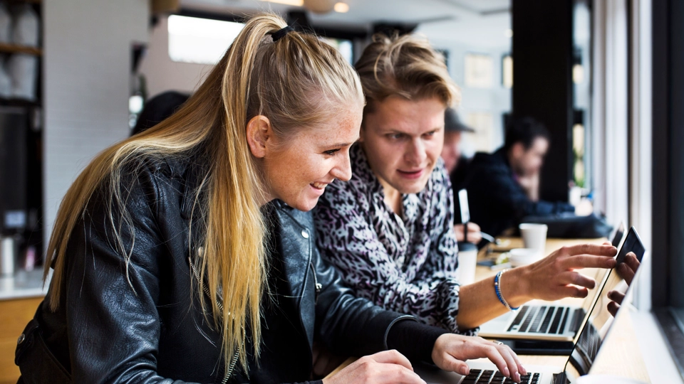 Två personer kollar på en laptop