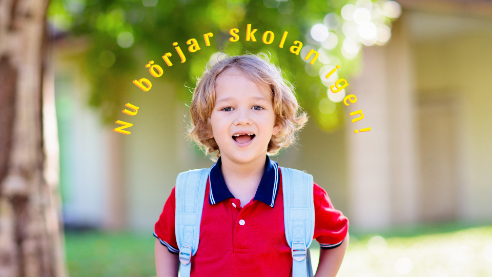 Glad pojke med skolväska på ryggen