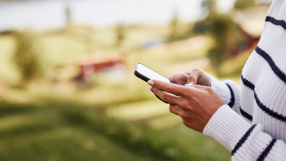 En kvinna som håller en mobiltelefon i händerna.