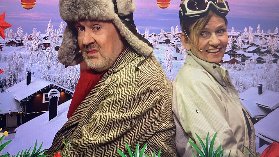 En man och en kvinna står med ryggarna mot varandra och tittar in i kameran. De är vinterklädda.