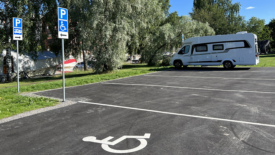 En husbil står parkerad på en av de nya ställplatserna. I förgrunden syns symbol för parkering för rörelsehindrade.