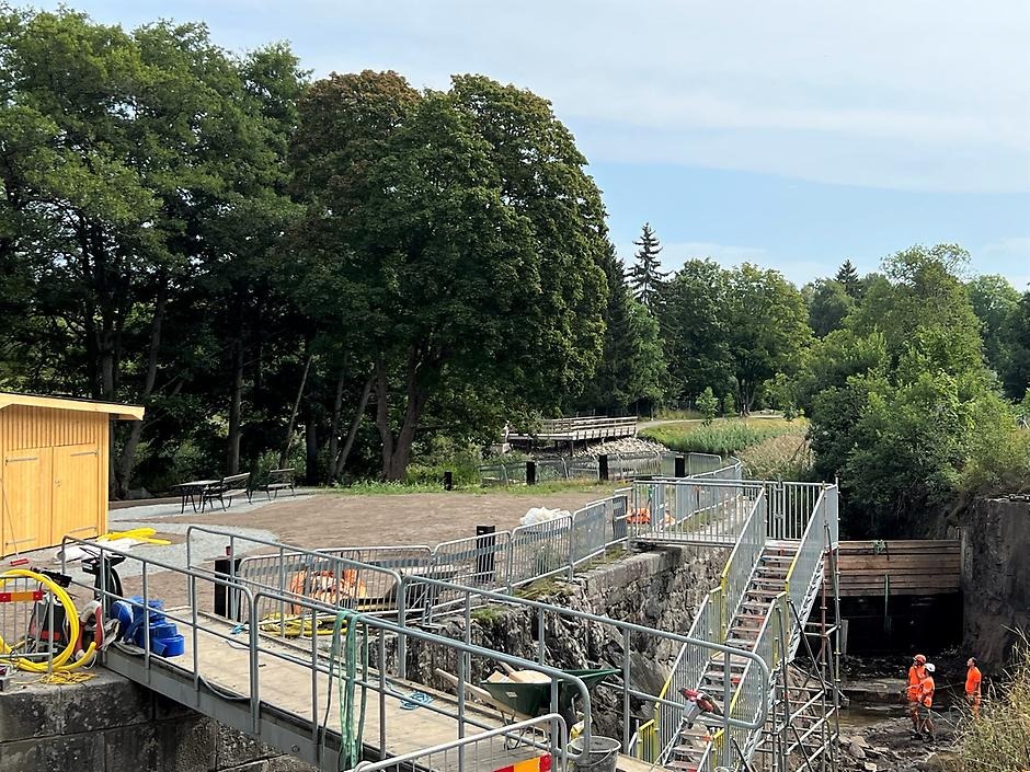 Slussen och Slussholmen. Slusskanalen är tömd på vatten och människor i orange varselkläder går omkring på botten.