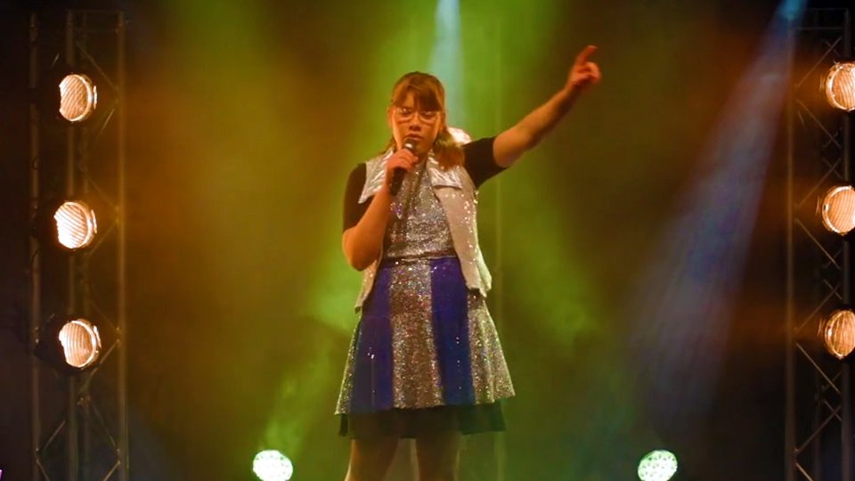 Sofia Stenkrona står på scenen och uppträder på Funkisfestivalen