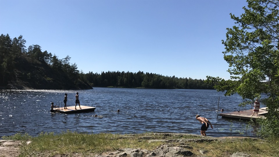 Badplats med personer som badar