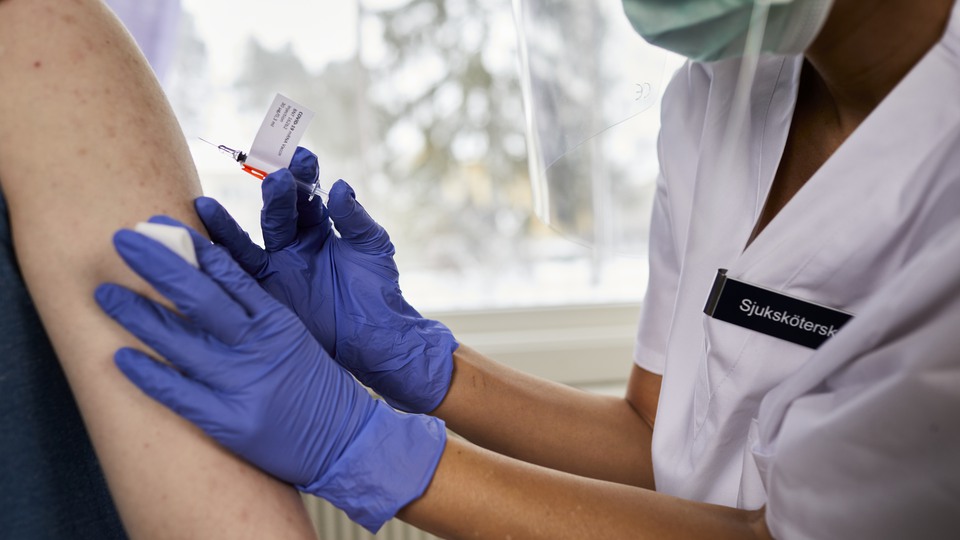 Två personer och en vaccinspruta
