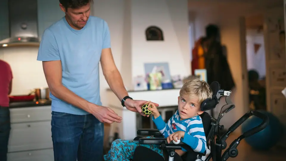 Vuxen hjälper barn att ta en boll