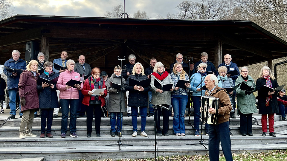 Bilden visar Åkersberga kammarkör som sjunger i trappen på dansbanan på Ekbacken.