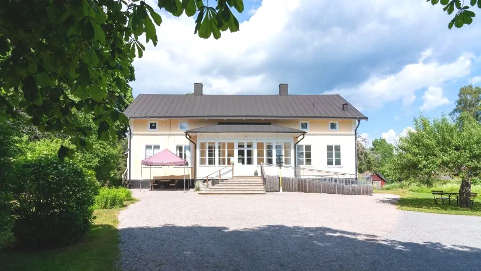 Bild på Ljusterö öppna förskola. Gult hus i solsken