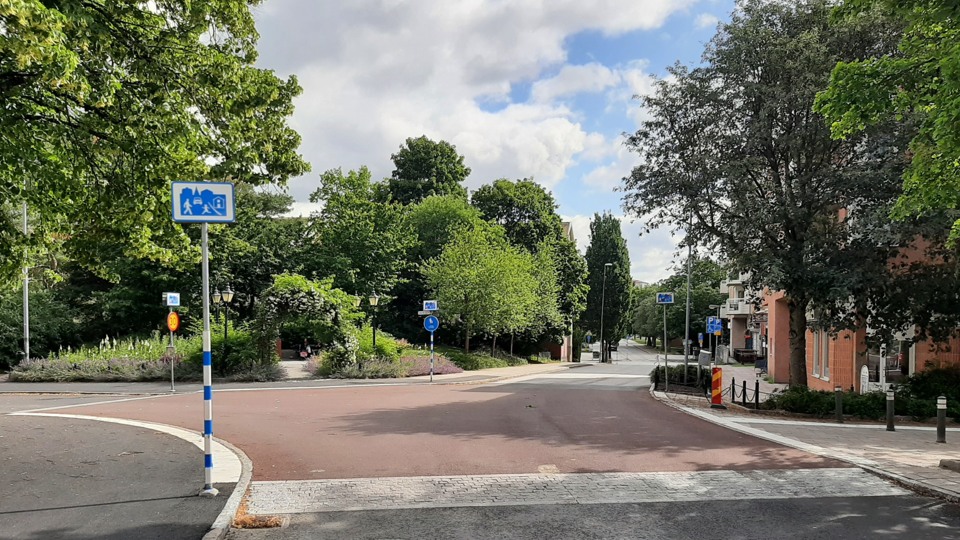Gångfartsområde vid korsningen Bergavägen och Storängsvägen med upphöjd nivå och rödmålad asfalt. 