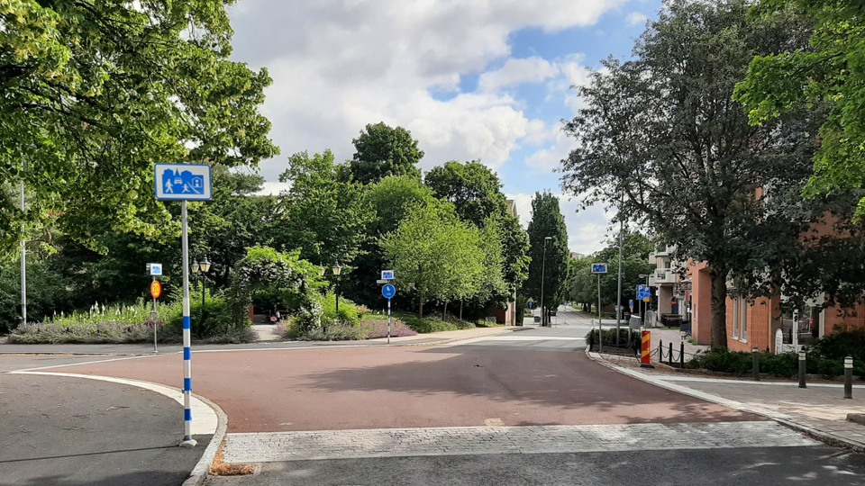 Gångfartsområde vid korsningen Bergavägen och Storängsvägen med upphöjd nivå och rödmålad asfalt.