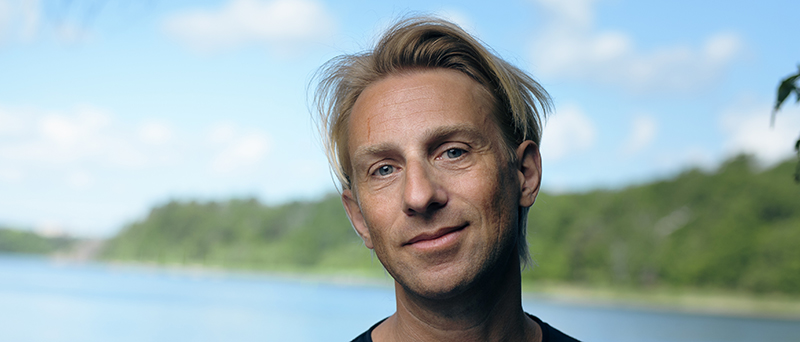 Leende man med blont, halvlångt hår