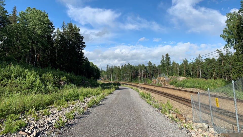 En grusväg längs Roslagsbanan. Det är sommar på bilden.