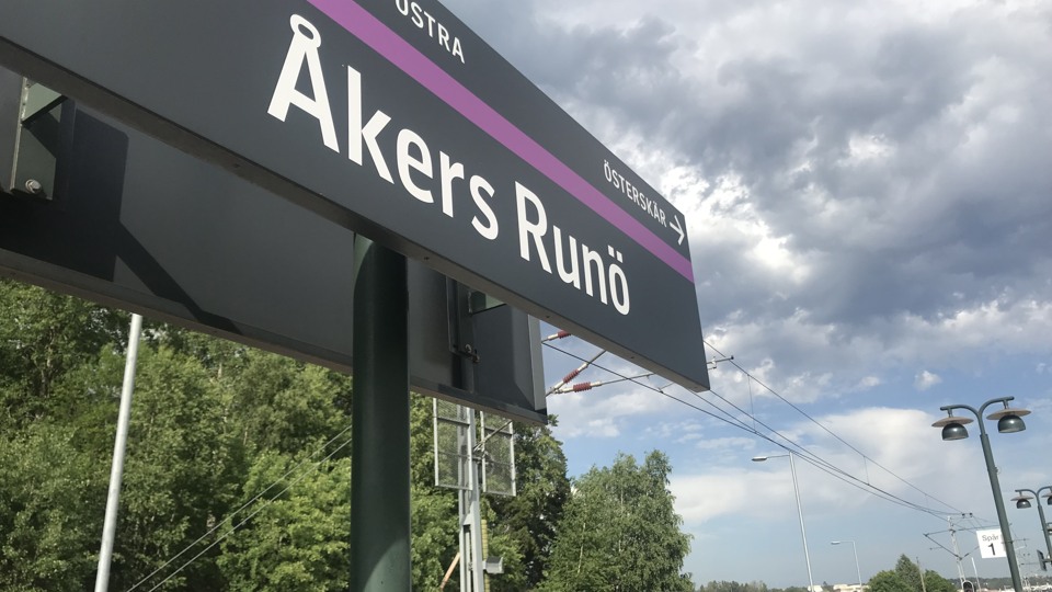 En skylt på en tågstation längs Roslagsbanan där det står Åkers Runö på skylten.