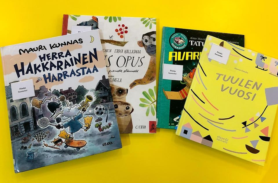 Neljä kirjaa keltaisella pohjalla