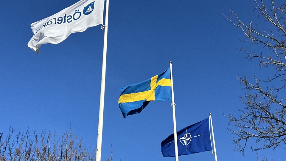 Bilden visar Österåkers, Sveriges och Natos flagga