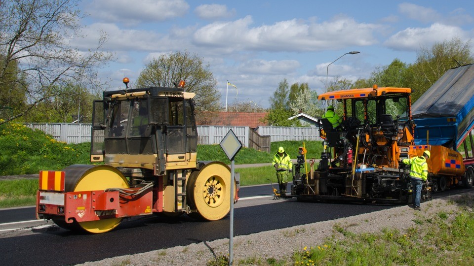 Beläggningsarbete pågår med ny asfalt på vägen.